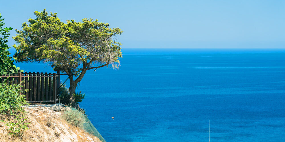 bel-olivier-falaise-au-dessus-mer-bleu-vif-bateau-pres-du-cap-greco-ile-chypre-mer-mediterranee