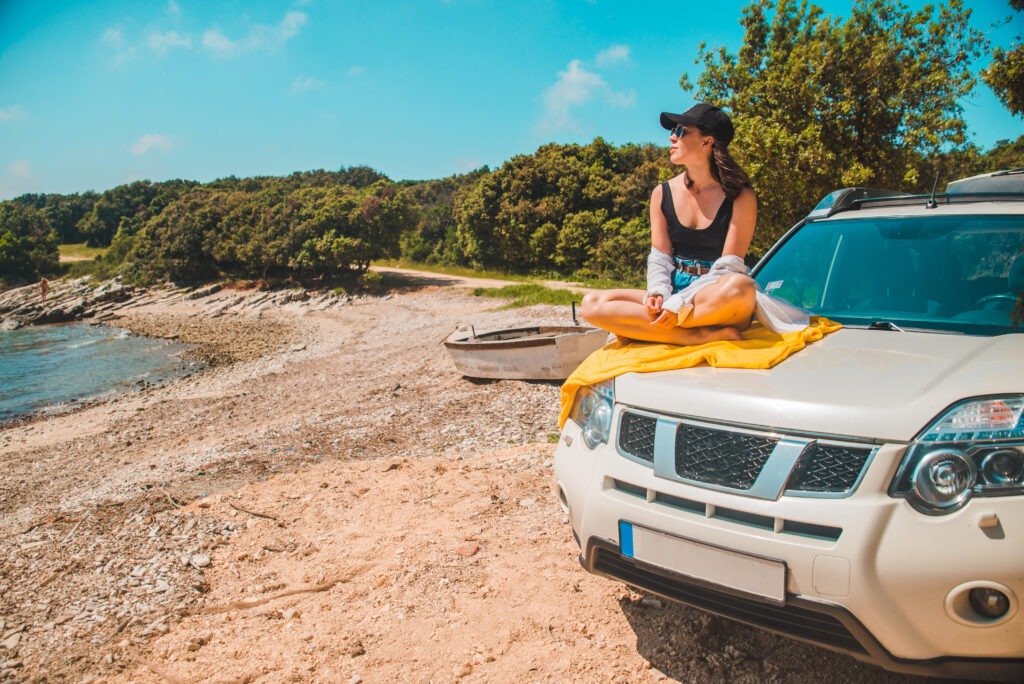 happy-woman-sea-summer-beach-sitting-car-hood