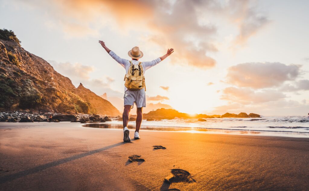 french-travel-agency-young-man-arms-outstretched-by-sea-sunrise-enjoying-freedom-life-people-travel-wellbeing-concept